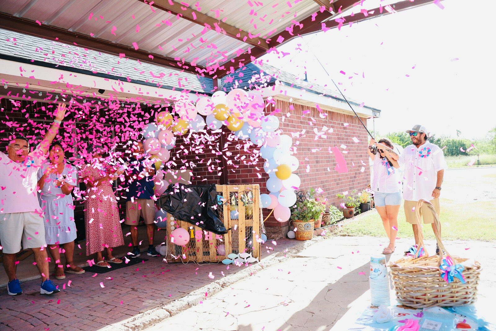People celebrating with pink confetti and balloons